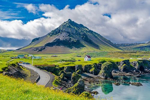 Mountain Stapafell in the background at Arnarstapi Village in summer sunny day in Iceland © takepicsforfun/Shutterstock
