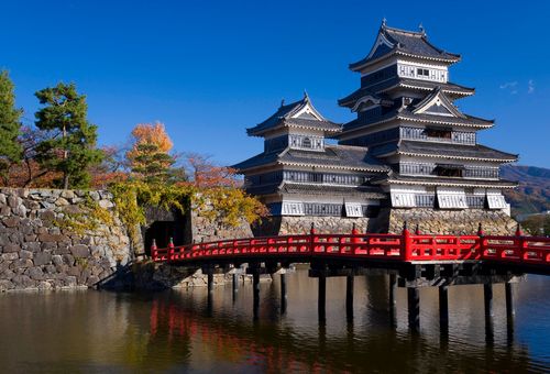 Japan, Central Honshu (Chubu), Nagano Prefecture, Matsumoto, Matsumoto-jo (Matsumoto Castle), the three-turreted donjon was built in 1595 in contrasting black and white, surrounded by a moat with access across handsome ornate red bridges