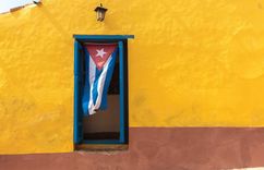 Travel Guide Cuba - Cuban flag in a doorway in Trinidad